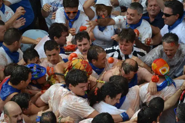 Multitud en fiestas de Tarazona, cubiertos de tomate, en medio de una batalla de tomates.