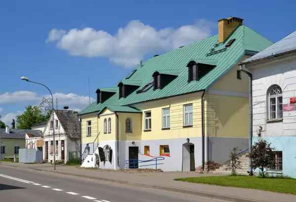 Kolorowe kamienice w Sejnach, z zielonymi dachami i licznymi oknami, tworzą urokliwy krajobraz. To jedne z wielu atrakcji Sejn.