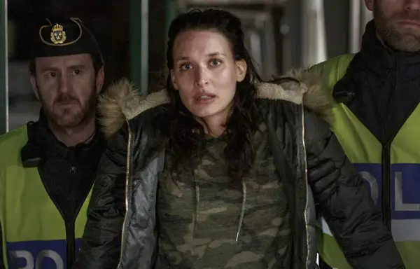 En kvinna omgiven av poliser i en dramatisk scen från en norsk serie på SVT.