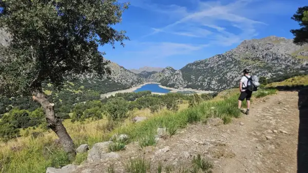 Randonneur contemplant le lac du Gorg Blau, un paysage emblématique du GR221 à Majorque.