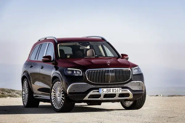 Luksusowy, bordowy GLS Maybach z chromowanymi felgami stoi na pustkowiu, gotowy na każdą podróż.