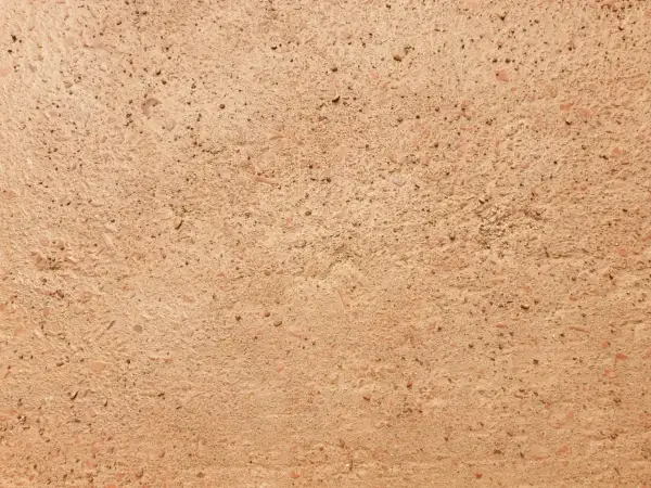 Dettaglio di un antico cocciopesto pavimento, con frammenti di terracotta e pietre che creano una texture rustica e calda.