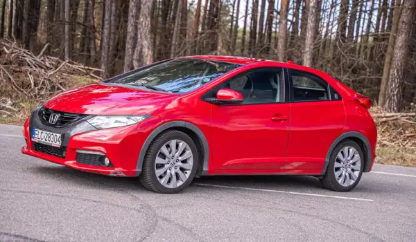 Czerwony Honda Civic UFO na leśnej drodze.