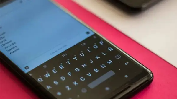 Pantalla de un smartphone con teclado QWERTY. Se busca cómo quitar vibración teclado para una experiencia más silenciosa.