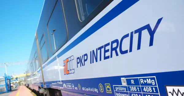 Biało-niebieski pociąg PKP Intercity na tle błękitnego nieba. Idealny na letnie podróże i promocje Intercity.