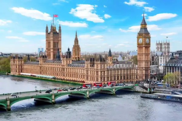 Parlamentshuset och Big Ben i London, med en bro och trafiken som visar det typiska klimat london.