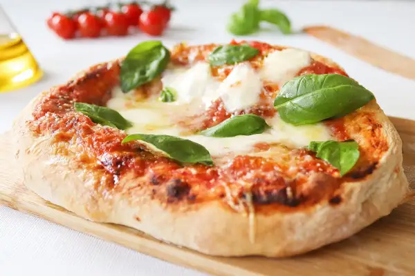 Pizza napolitana casera, con tomate, mozzarella fundida y albahaca fresca. ¡Una delicia para tu receta!