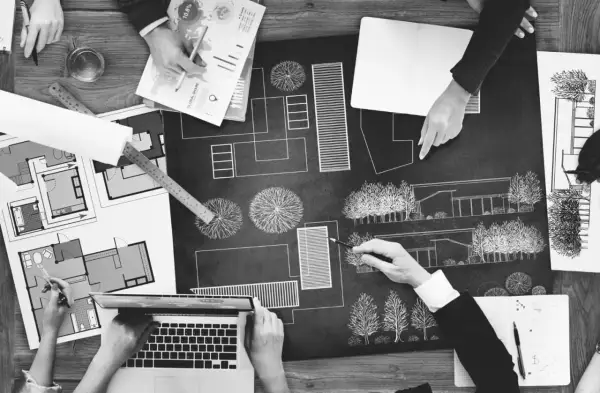 Zespół dyskutuje nad projektem architektonicznym, planując przestrzeń. To kluczowy etap reformy planowania przestrzennego.