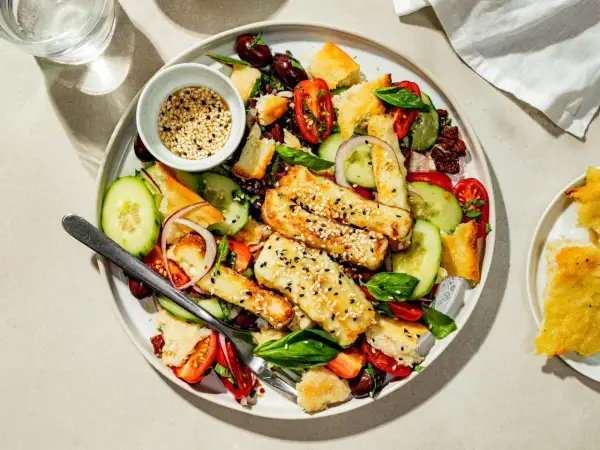 En härlig halloumi sallad med krispiga krutonger, tomater, gurka och oliver. Toppad med sesamfrön.