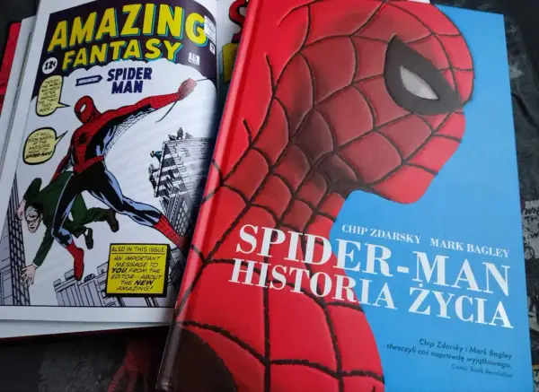 Okładka książki "Spider-Man: Historia Życia" z wizerunkiem Spider-Mana. Obok komiks "Amazing Fantasy" z pierwszym pojawieniem się bohatera.
