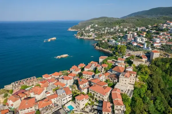 Widok z lotu ptaka na malowniczą ulcinj plaża z kamiennymi domami i turkusowym morzem.