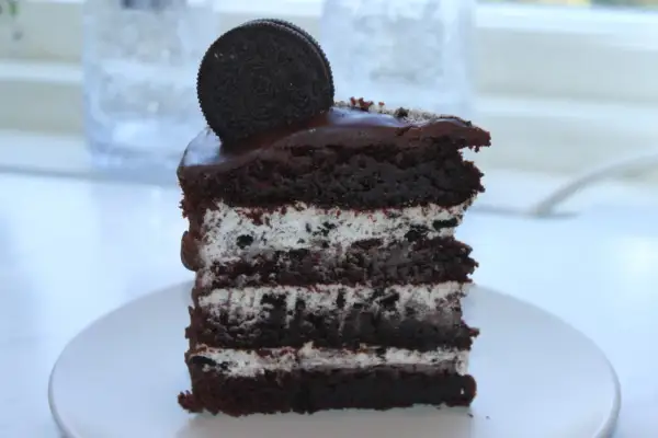 En bit chokladkaka med lager av krämig fyllning och krossade oreos. En hel oreo kex toppar denna läckra oreo tårta.