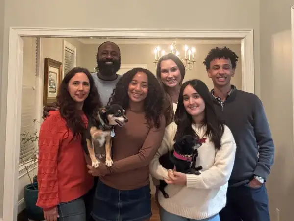 La familia anfitriona posa sonriente con sus dos perros.