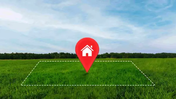 Un terreno verde con un marcador rojo de casa en el centro. Ideal para tu hipoteca para comprar terreno y construir tu hogar soñado.