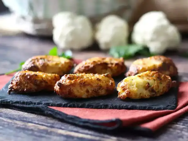 Krispiga blomkålsbiffar på en svart skifferplatta, ett perfekt middagstips för en hälsosam och god måltid.