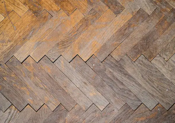 Parquet in legno con motivo a spina di pesce, usurato ma pronto per essere lucidato con rimedi della nonna per farlo brillare.