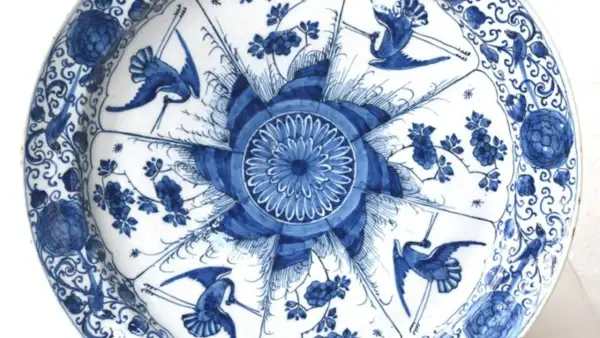 Piatto in ceramiche di Delft blu e bianche con gru e fiori.