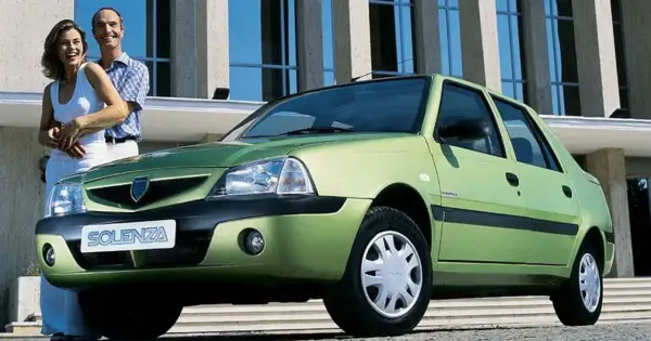Szczęśliwa para obok zielonej Dacii Solenza. Wyobraź sobie podróż w 2026 roku tym niezawodnym autem.