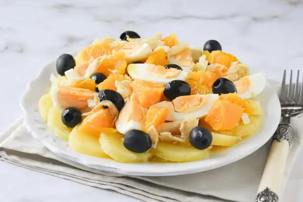 Ensalada malagueña con patatas, naranja, huevo duro, bacalao desmigado y aceitunas negras.