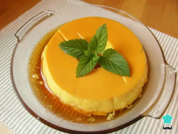 Delicioso flan de leche condensada al baño maría, decorado con hojas de menta fresca.