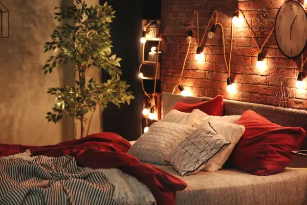 Atmosfera accogliente con luci soffuse e cuscini morbidi: ecco delle idee camera da letto per un relax totale.