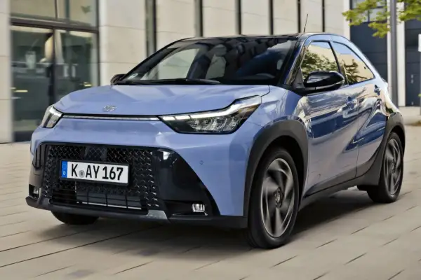 Niebieskie Toyota Aygo X w ruchu. Sprawdź atrakcyjną toyota aygo x cena i wyposażenie.