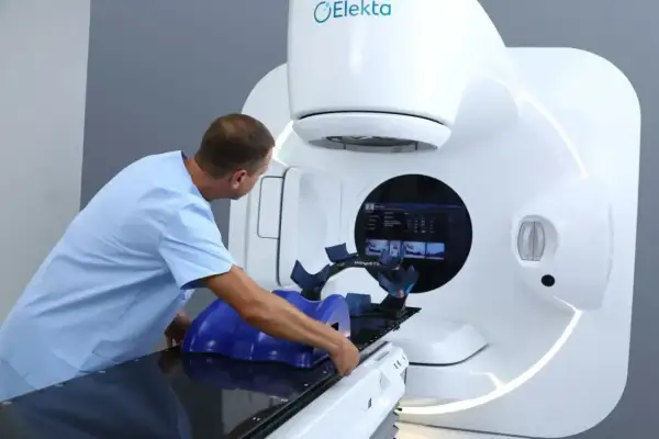 Medyk przygotowuje pacjenta do radioterapii na nowoczesnym urządzeniu Elekta.