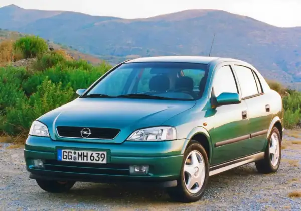 Zielony Opel Astra Classic 1999 na tle górskiego krajobrazu.
