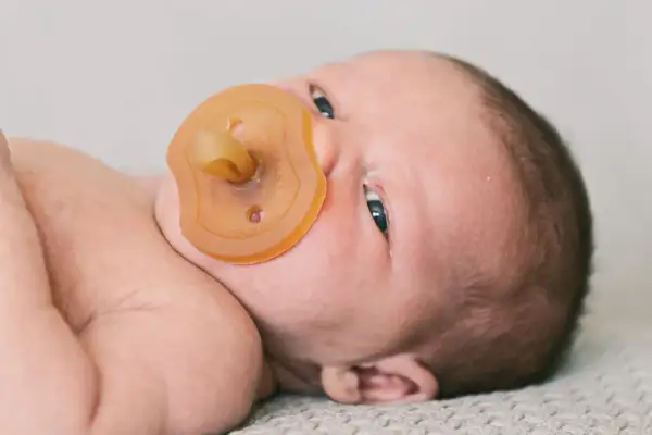 Neugeborenes Baby mit Schnuller. Die Frage "ab wann Schnuller?" beschäftigt viele Eltern.