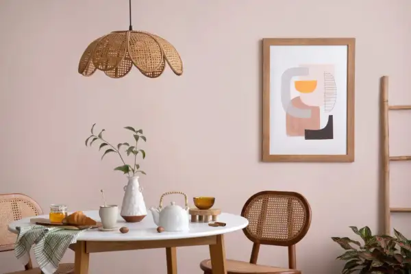 Stół z croissantem i miodem, wazon z gałązką, dzbanek i obraz w stylu abstrakcyjnym. Paleta kolorów dekoral idealnie pasuje do tego wnętrza.