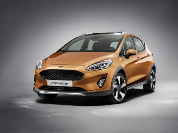 Pomarańczowy Ford Fiesta MK9 z czarnymi akcentami i relingami dachowymi, gotowy na miejskie przygody.