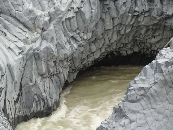 Die Alcantara Schlucht in Sizilien zeigt faszinierende Basaltsäulen, die von einem türkisfarbenen Fluss umspült werden.