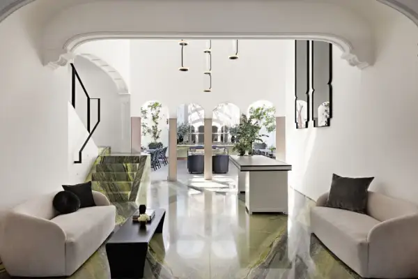 A modern living space with green marble floors and a striking staircase, feeling chic by accident in Mexico City.