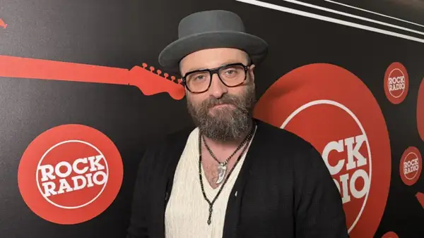 Mężczyzna w kapeluszu i okularach, z brodą, na tle logo Rock Radia. Widać napis "perfect wszystko ma swój czas tekst".