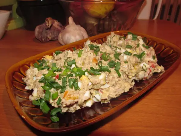 Pyszna pasta z sardynek z jajkiem i szczypiorkiem, podana na brązowym talerzu.