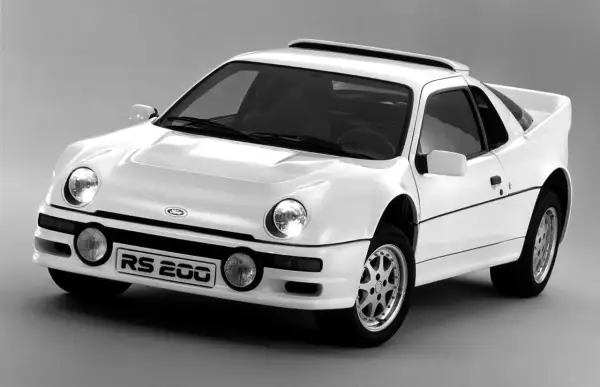 Biały Ford RS200, jeden z legendarnych modeli Forda, z charakterystycznym spojlerem i okrągłymi światłami.