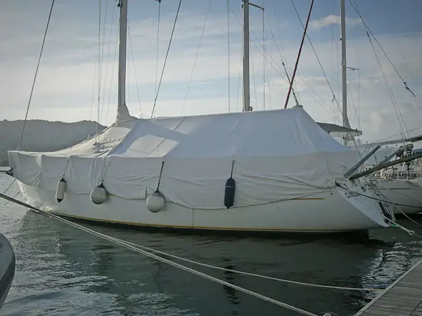 Barca a vela coperta con un telo per barca fai da te, pronta per l'inverno.
