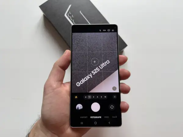 Ręka trzyma telefon Samsung Galaxy S25 Ultra z otwartą aplikacją aparatu. Widoczne opcje: portret, fotografia, wideo. Dowiedz się, jak ustawić aparat w telefonie Samsung.