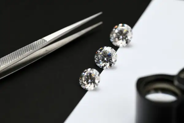 Pinzas y diamantes sobre fondo blanco y negro. Aprende como saber si un mineral es real.