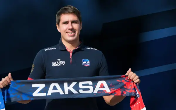 Tomasz Kalembka w koszulce ZAKSA trzyma szalik z napisem ZAKSA.