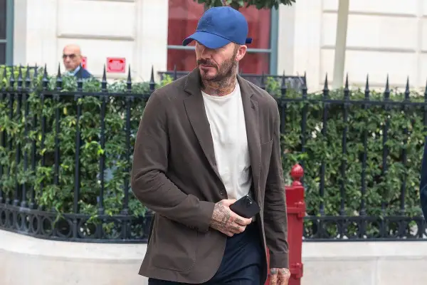 Uomo con cappellino blu e giacca marrone, dimostrando che blu e marrone stanno bene insieme.