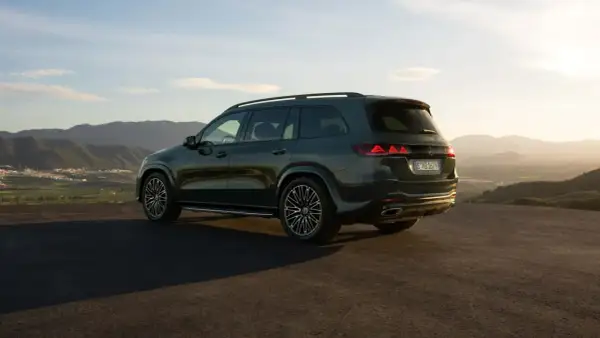 Mercedes más potente, un SUV oscuro aparcado en una colina con vistas a un valle al atardecer.
