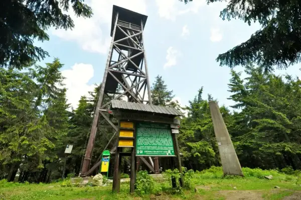 Drewniana wieża widokowa na Radziejowej. Obok tablica informacyjna i obelisk. To początek najkrótszego szlaku na Radziejową.