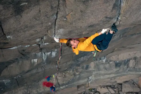 Ein Kletterer meistert eine anspruchsvolle **offwidth climbing** Route, seine Hände greifen fest in den Fels.