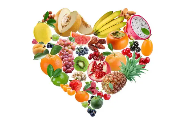 Un cœur de fruits et noix, une alimentation saine pour faire baisser le cholestérol. Melons, bananes, grenades, agrumes, baies, kiwis, ananas, amandes.