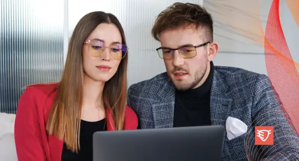 Para dyskutuje o tym, czy okulary ochronne psują wzrok, patrząc na laptopa.