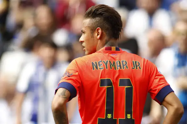 Neymar w Barcelonie, w pomarańczowej koszulce z numerem 11, na tle trybun.