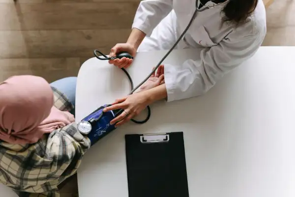 Arzt misst Blutdruck bei Patientin. Ein Beispiel für integrative Onkologie, die ganzheitliche Betreuung in den Vordergrund stellt.