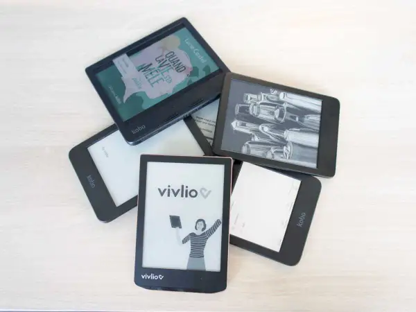 Pile d'e-readers Kobo et Vivlio, certains affichant des couvertures de livres ou des illustrations. Le logiciel Kobo est visible sur plusieurs appareils.