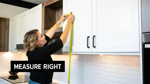 Woman demonstrating how to measure kitchen cabinets with a yellow tape measure. "Measure Right" text overlay.
